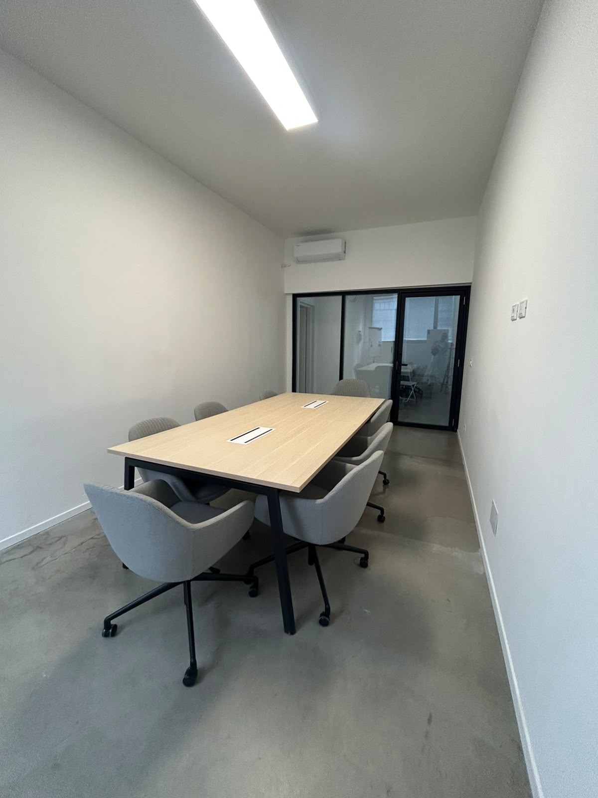 Sala meeting con tavolo in legno e sedute imbottite