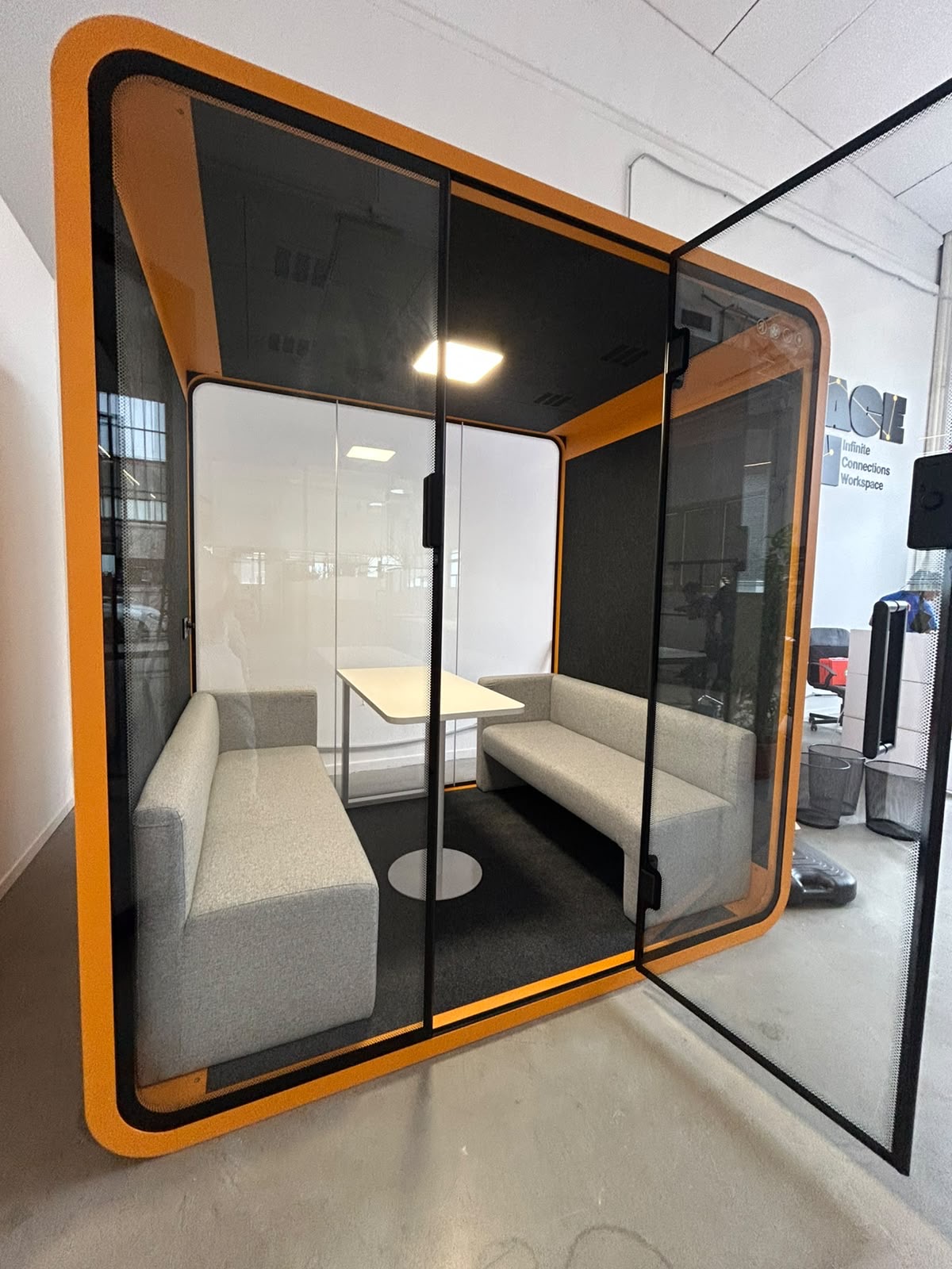 Pod insonorizzato arancione con sedute e tavolo